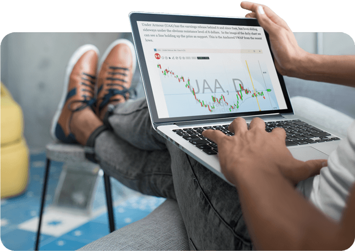 Man relaxing in a chair looking at his laptop with the Trade of the Week showing in his browser.